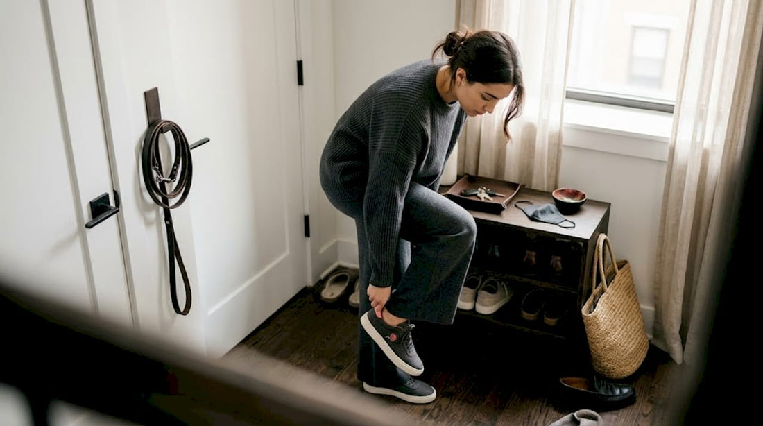 Woman adjusting comfortable shoes in entryway